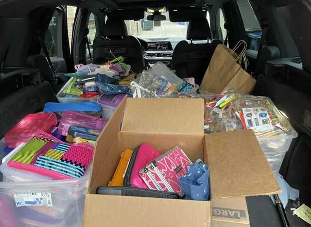 A vehicle loaded with boxes and bins of school supplies.