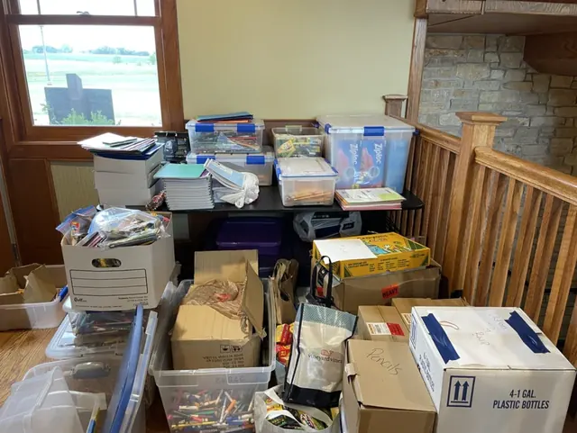 Collected donation boxes and storage tubs filled with school supplies.
