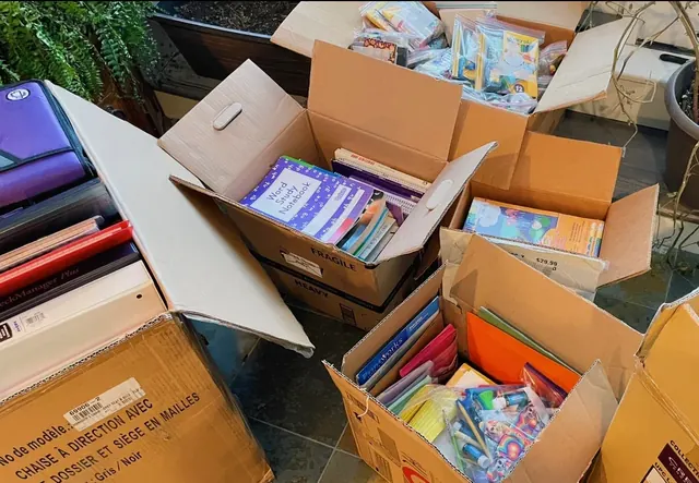 Open boxes filled with donated books and school supplies.